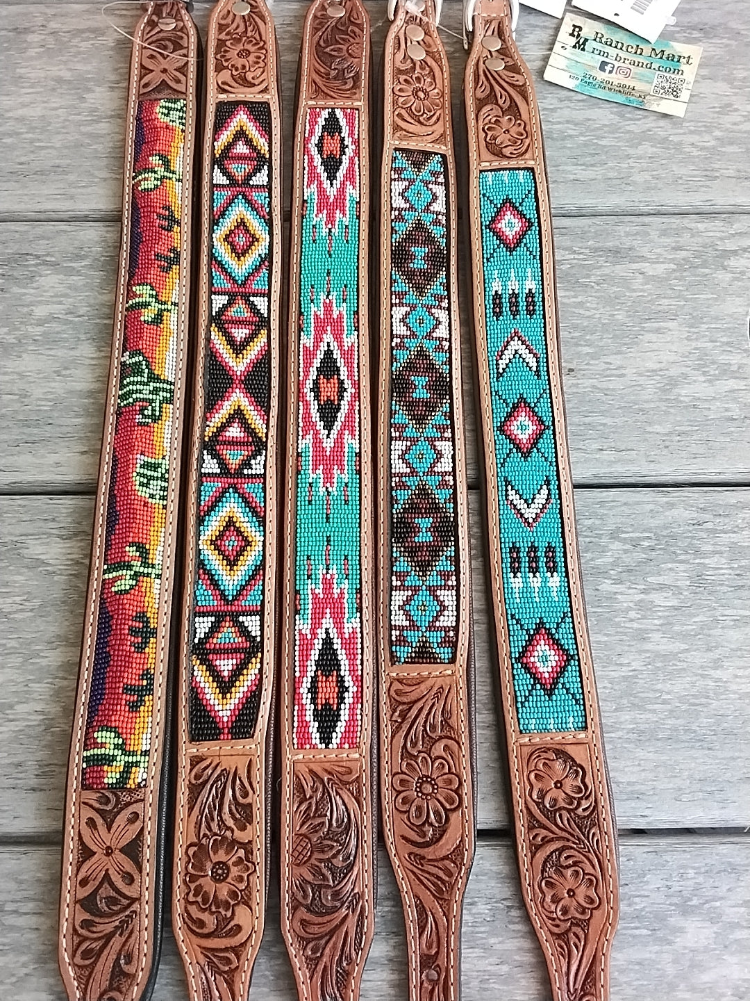 Set of leather straps with colorful bead patterns on a wooden surface