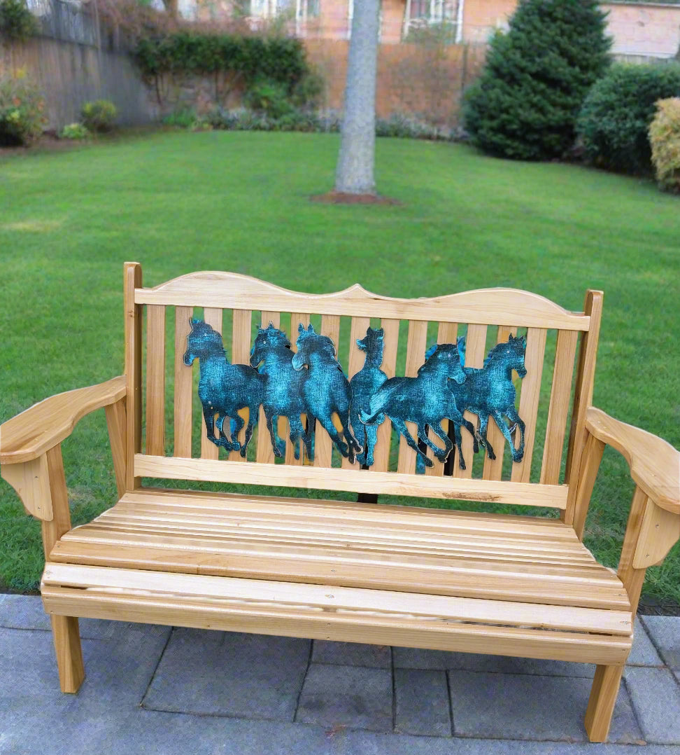 Wooden bench with horse designs in front of Adirondack chairs and a table.