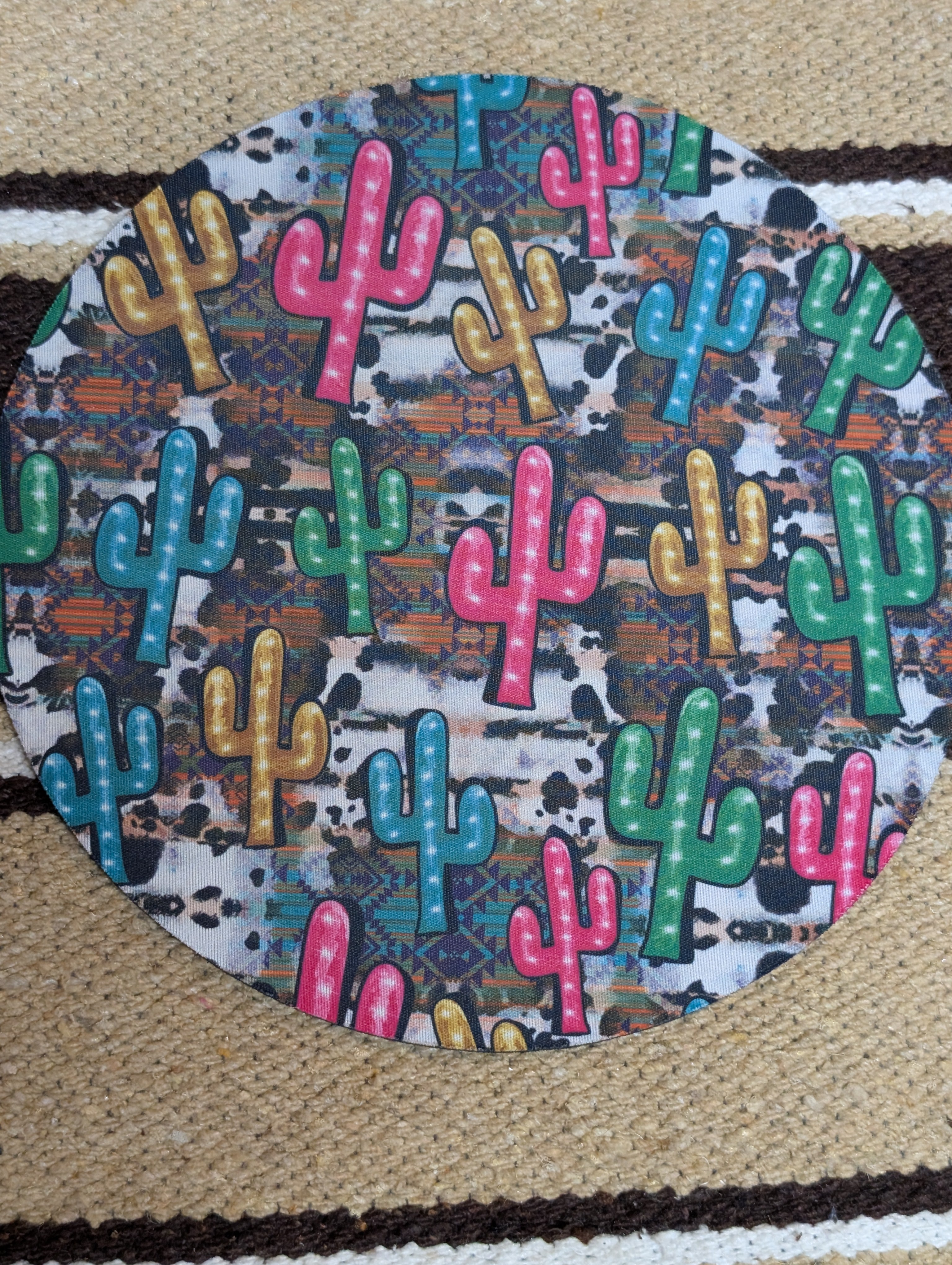 Round mat with colorful cactus pattern on a textured surface