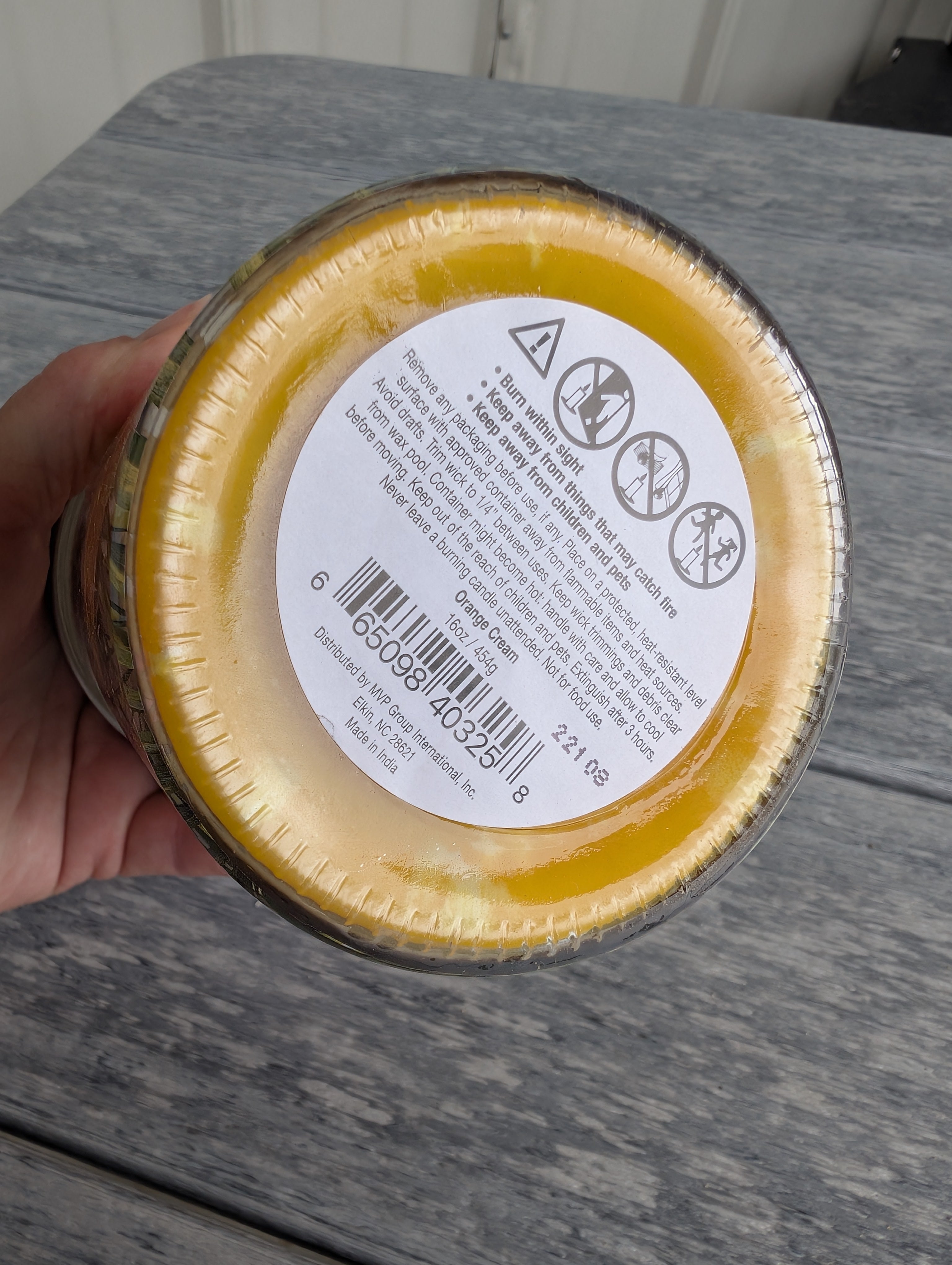 Citrus and vanilla-scented candle with lid, perfect for refreshing any room