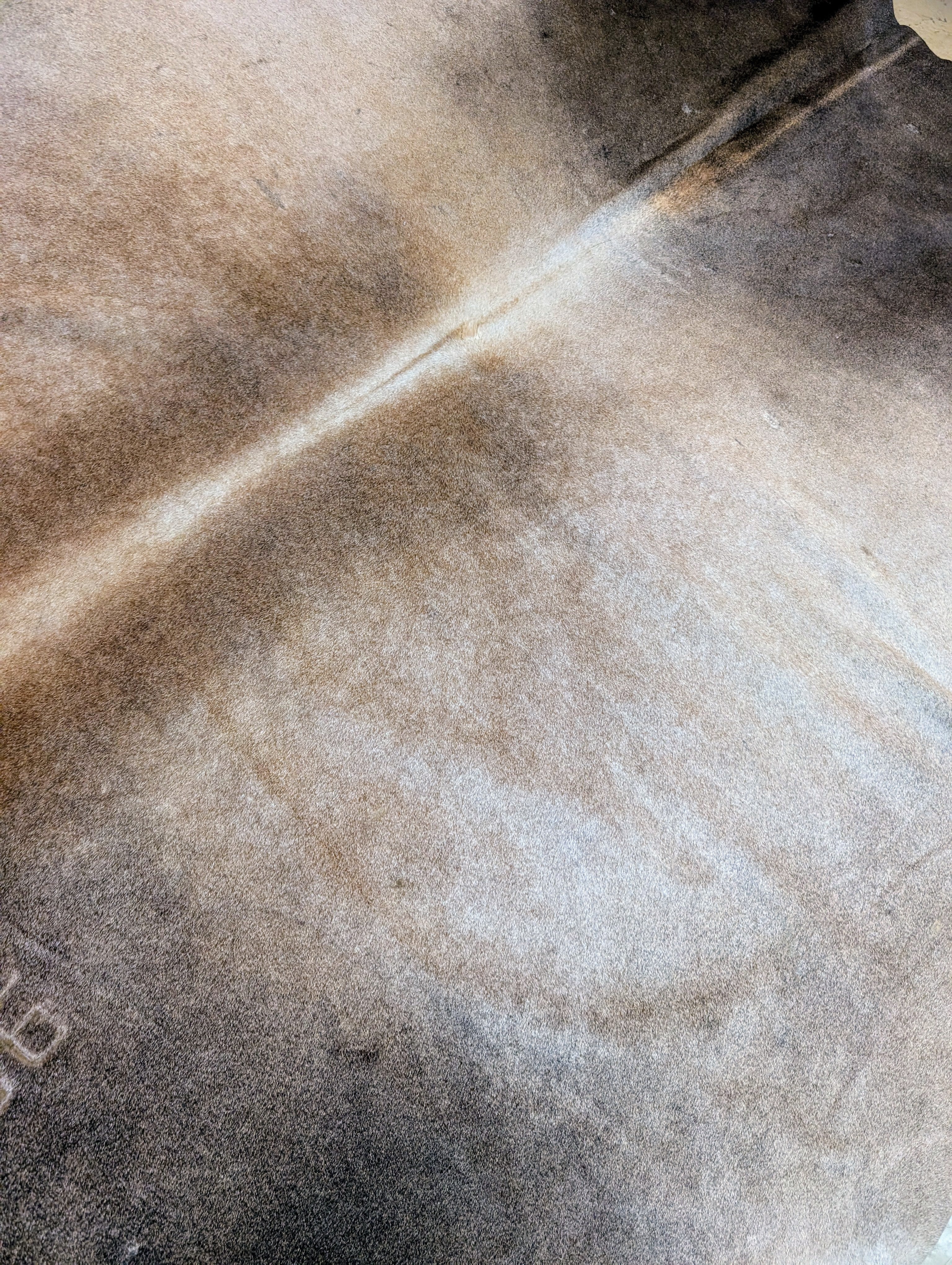 Authentic smokey brown cowhide with natural branding