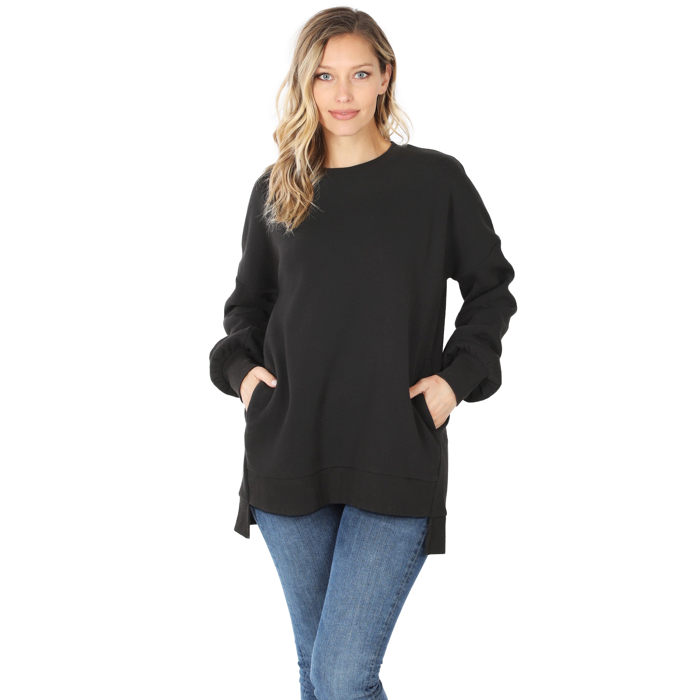 Woman wearing a black sweater and blue jeans on a white background
