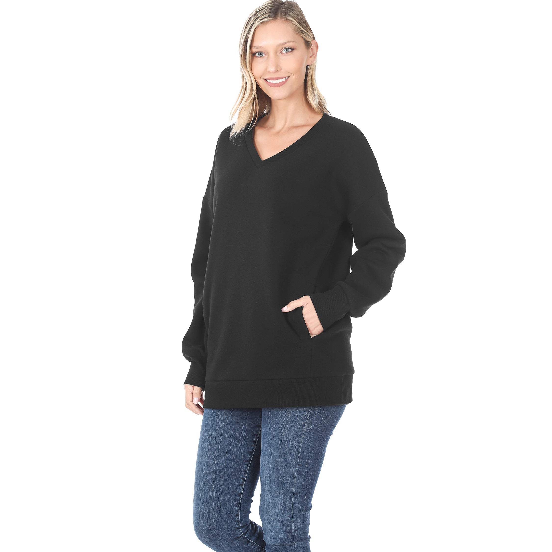 Woman wearing a black sweater and blue jeans on a white background