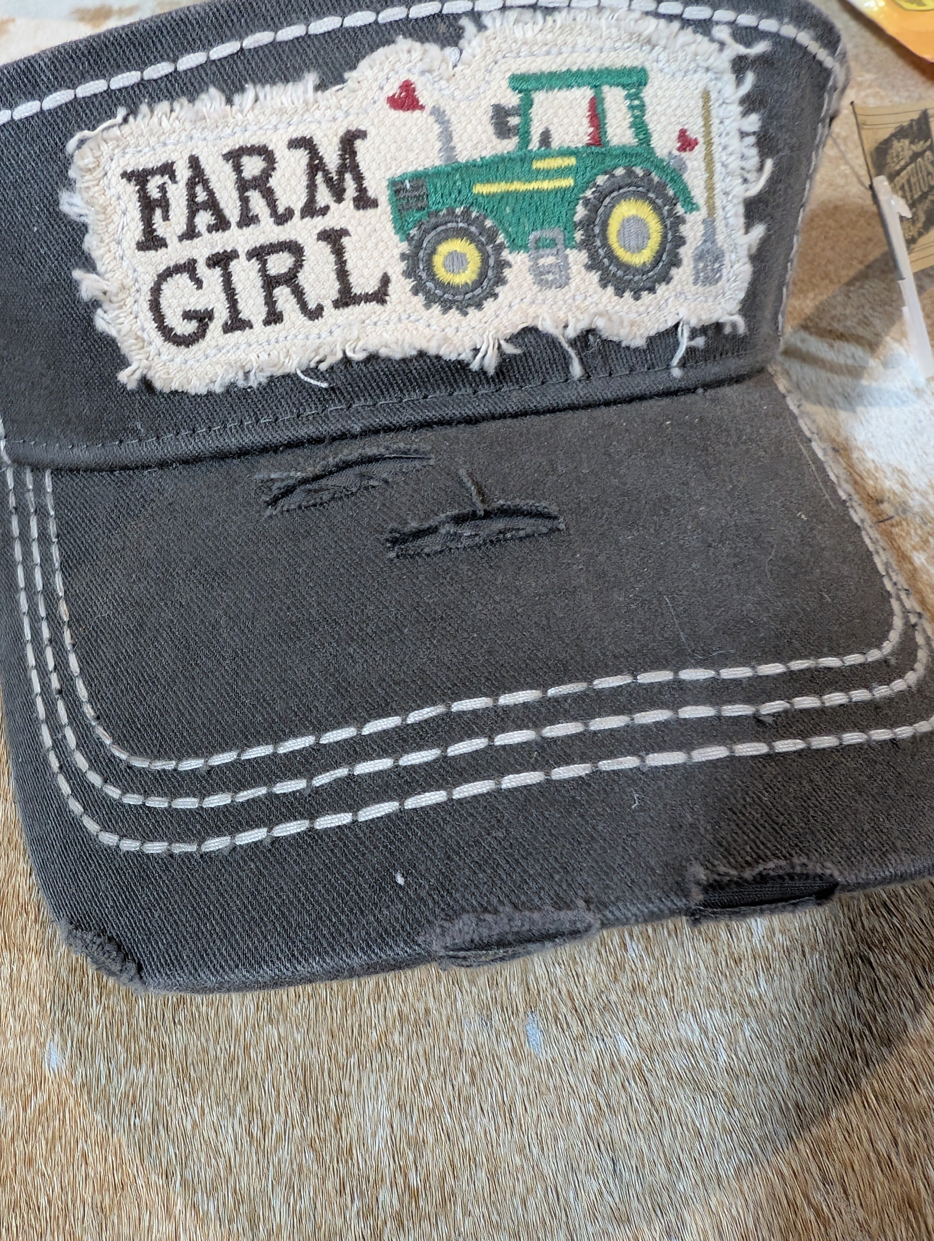 Gray visor with 'Farm Girl' and tractor design on a wooden surface