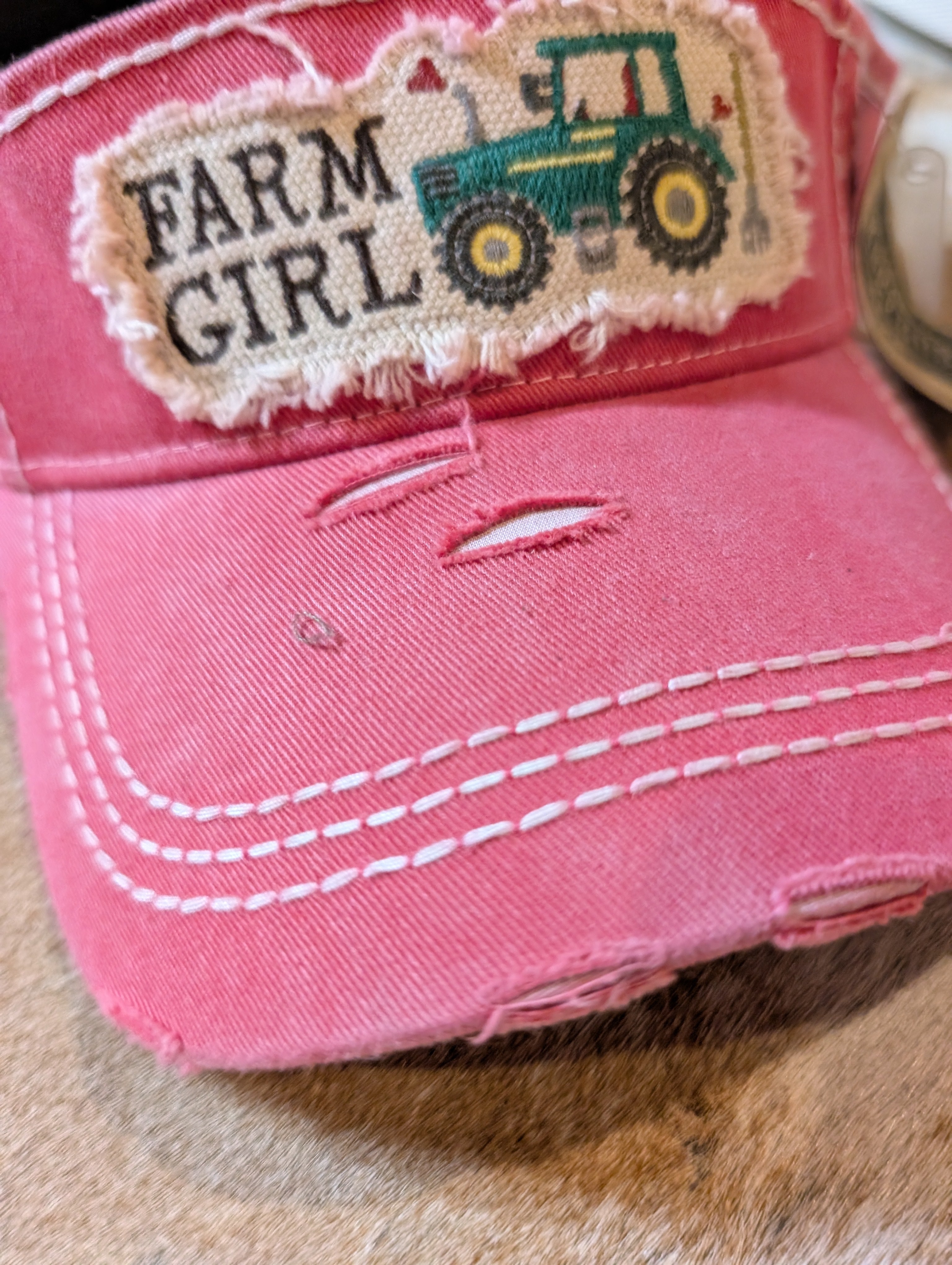Pink visor with 'Farm Girl' patch featuring a tractor on a fur surface