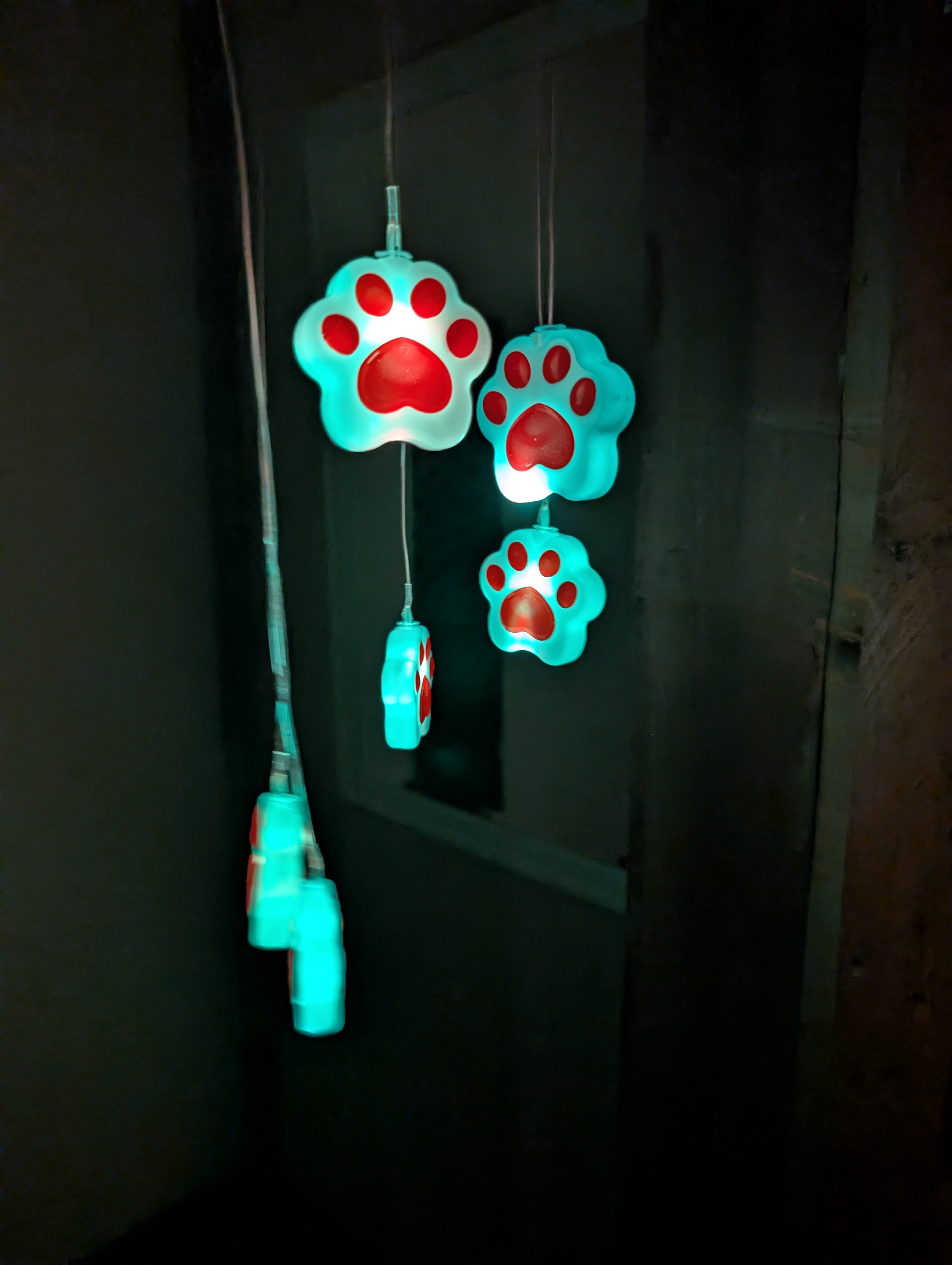Glowing paw-shaped lights on a dark background