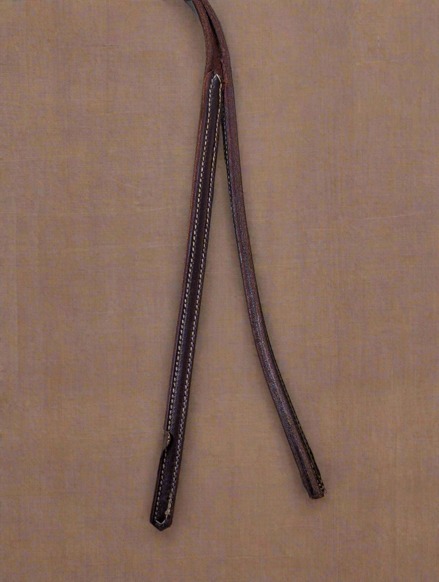 Brown leather strap with stitching on a beige surface, held by a hand.