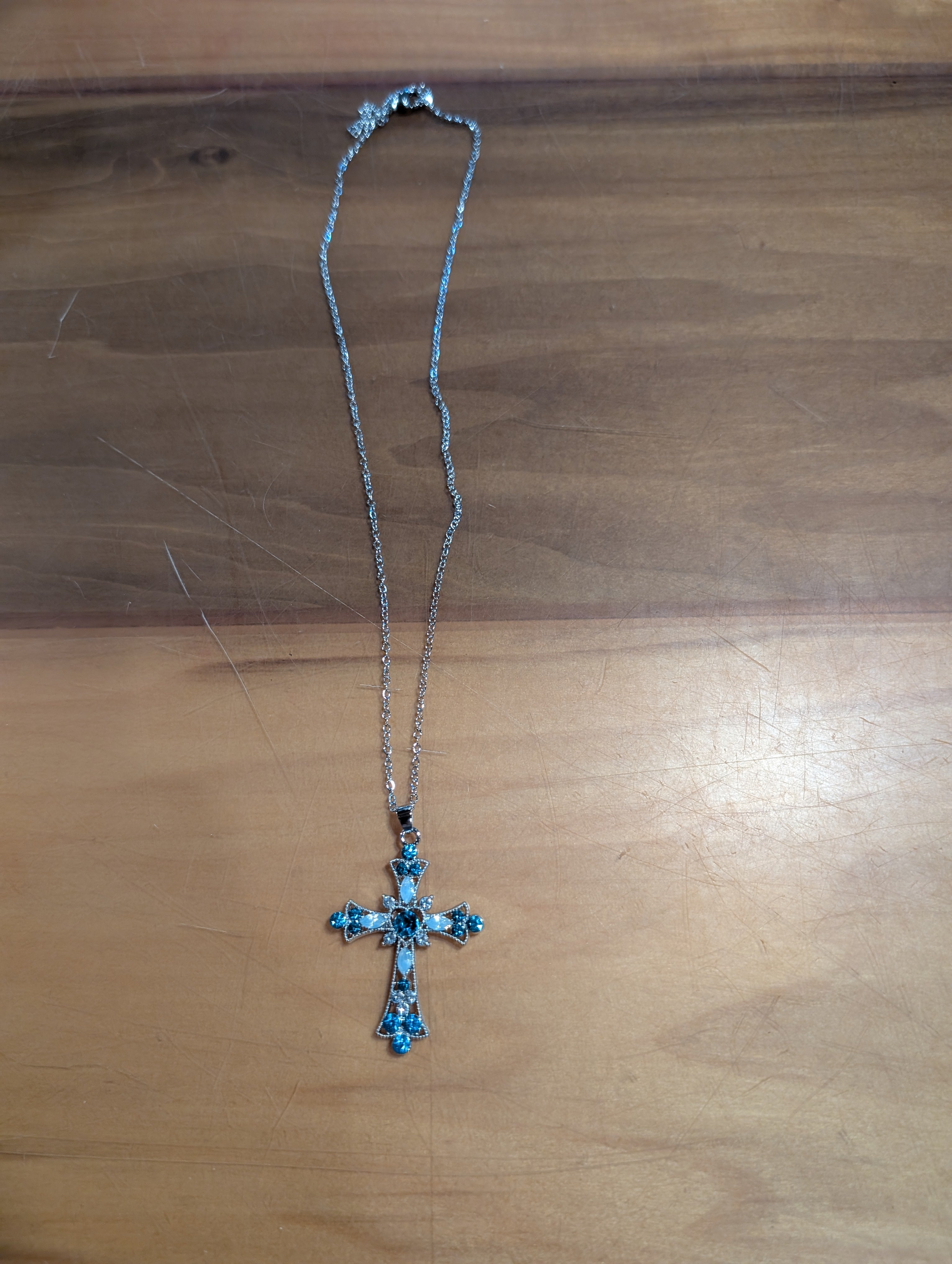 Necklace with a cross pendant on a wooden surface