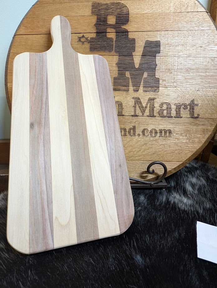 Wooden cutting board with striped pattern on a wooden surface with 'RM Mart' branding.
