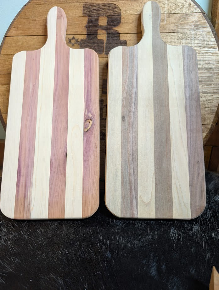 Two wooden cutting boards with striped patterns on a wooden surface.
