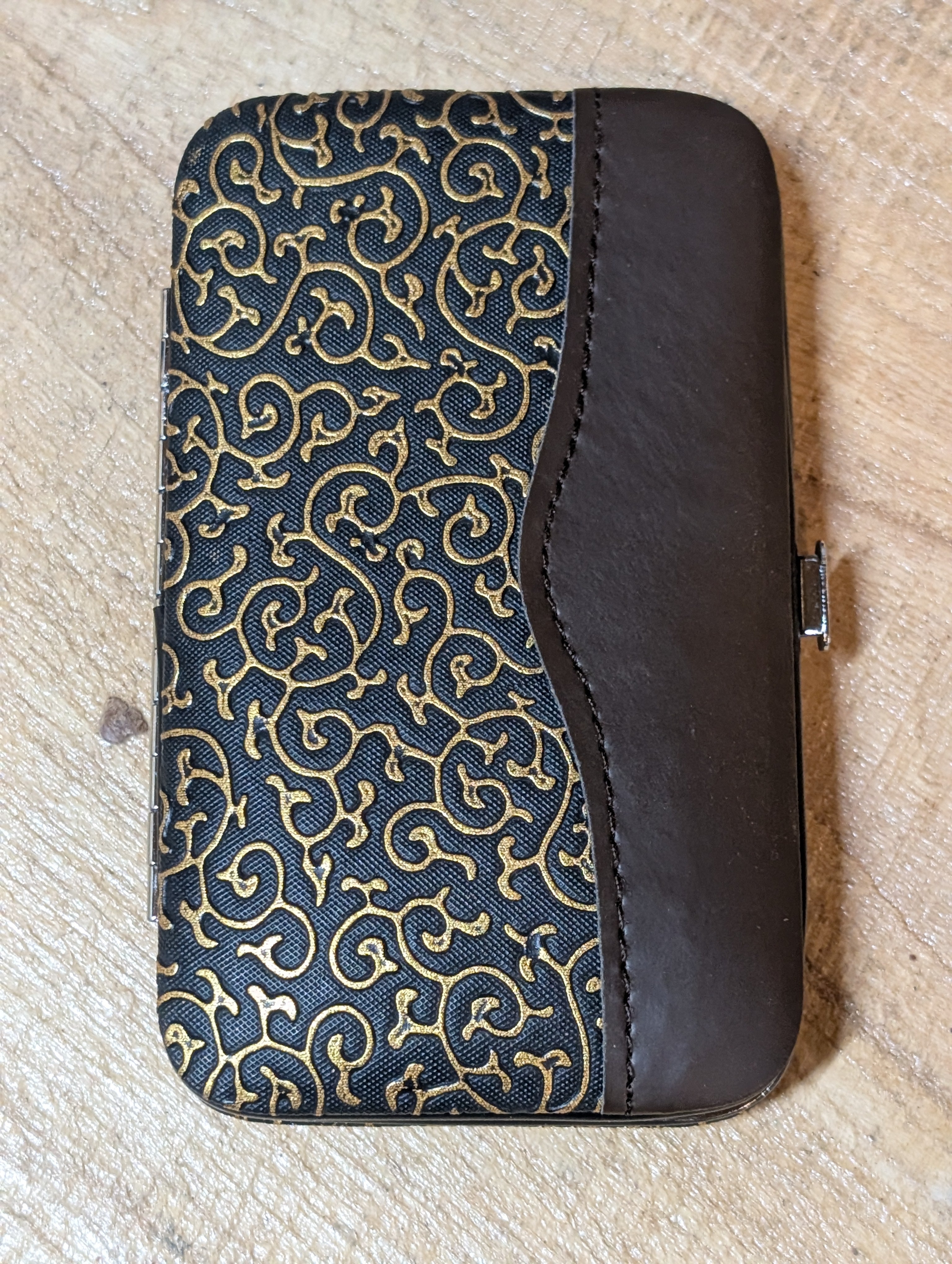 Patterned case with dark brown leather-like finish on a textured beige surface