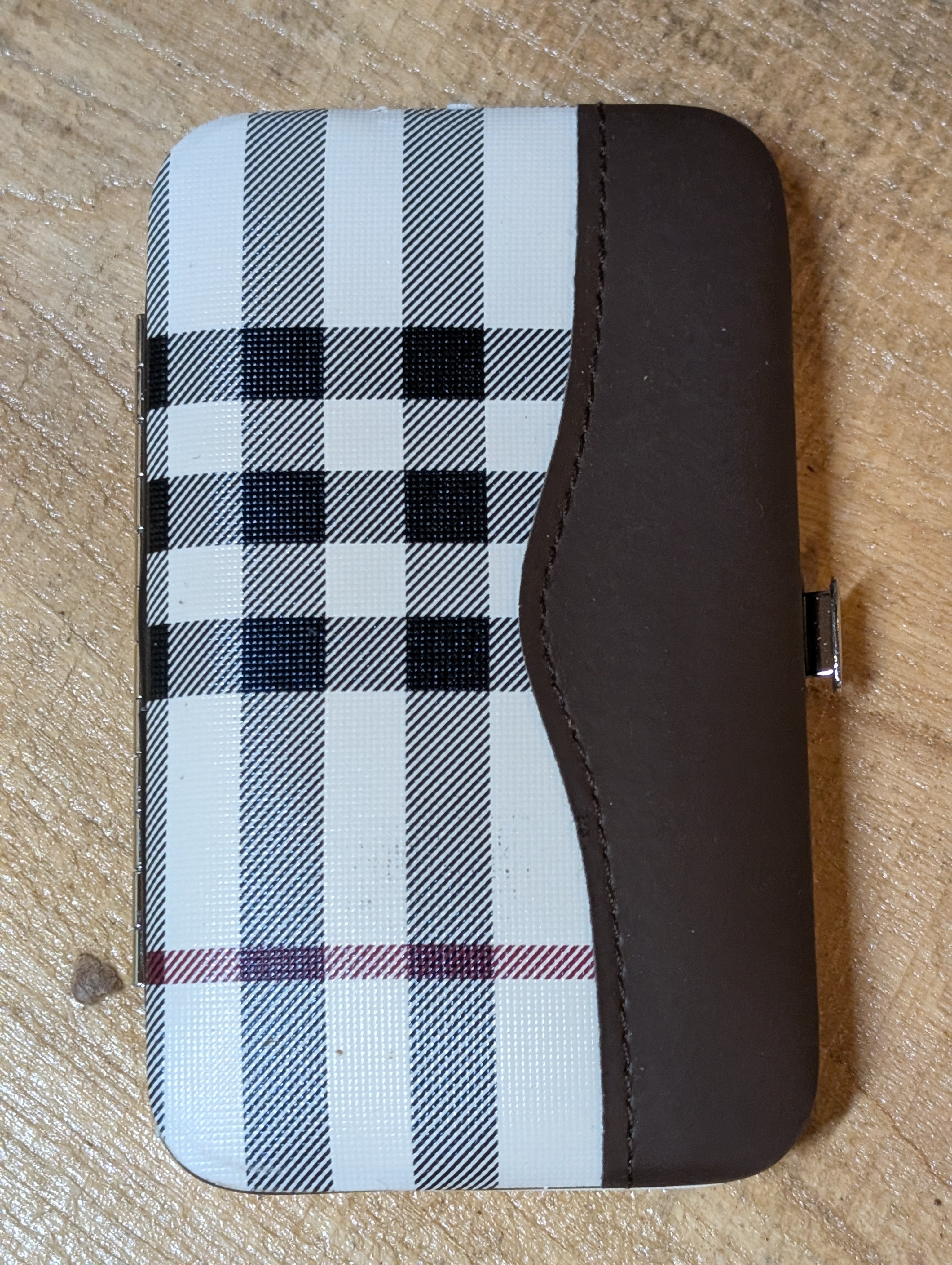 Plaid patterned case with brown border on a beige surface