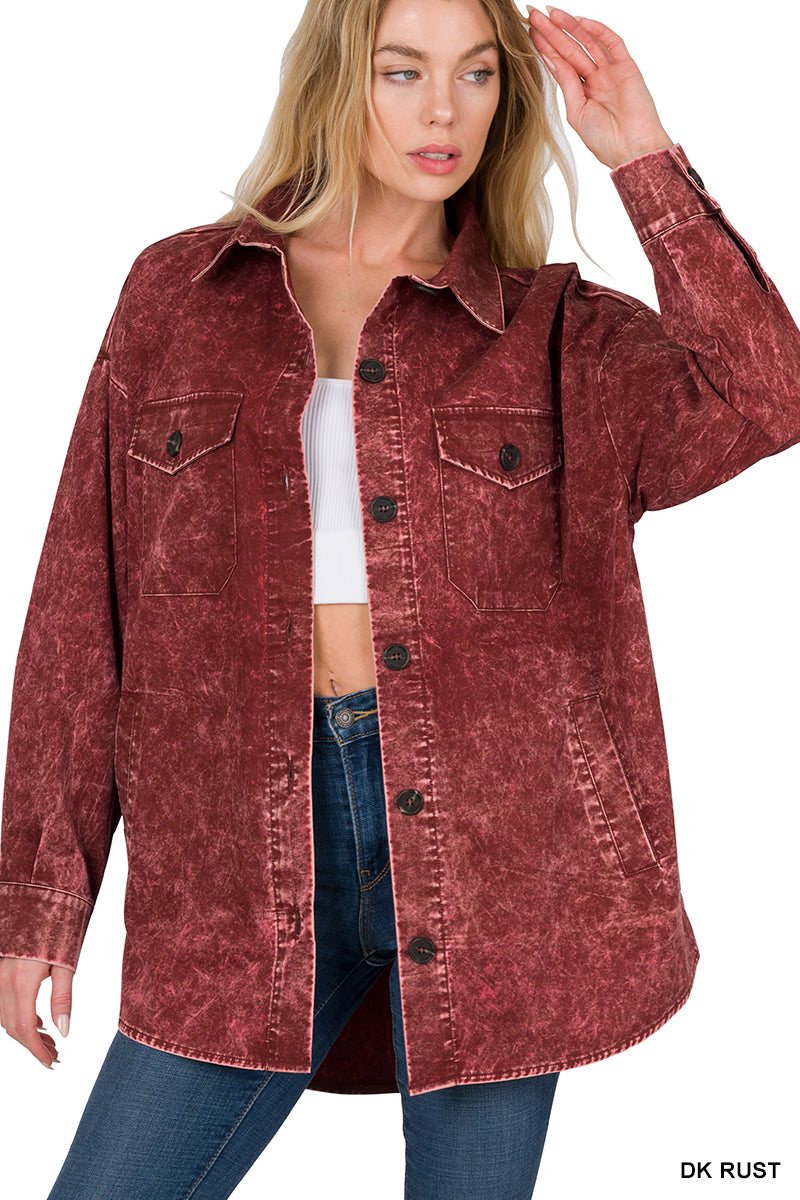 Woman wearing a dark rust-colored denim jacket on a white background
