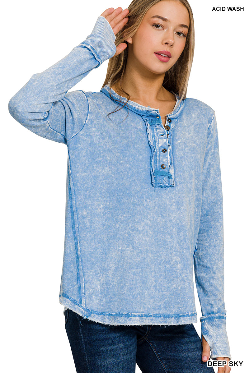 Woman wearing a blue acid wash long-sleeve top on a white background