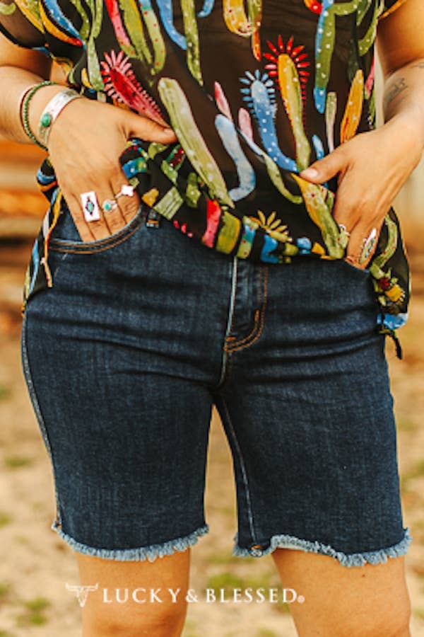 Model wearing dark wash denim shorts with a casual t-shirt outdoors