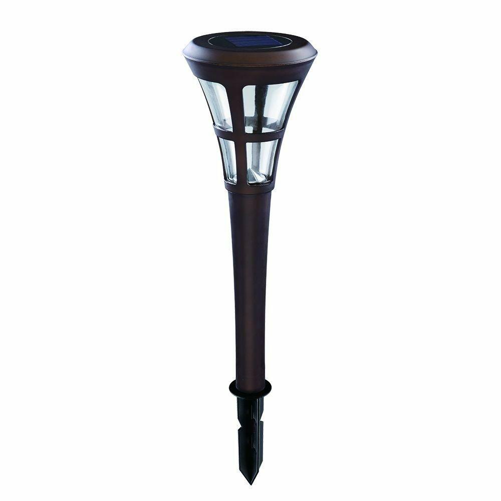 Solar-powered garden light with brown base and clear glass cover on a white background