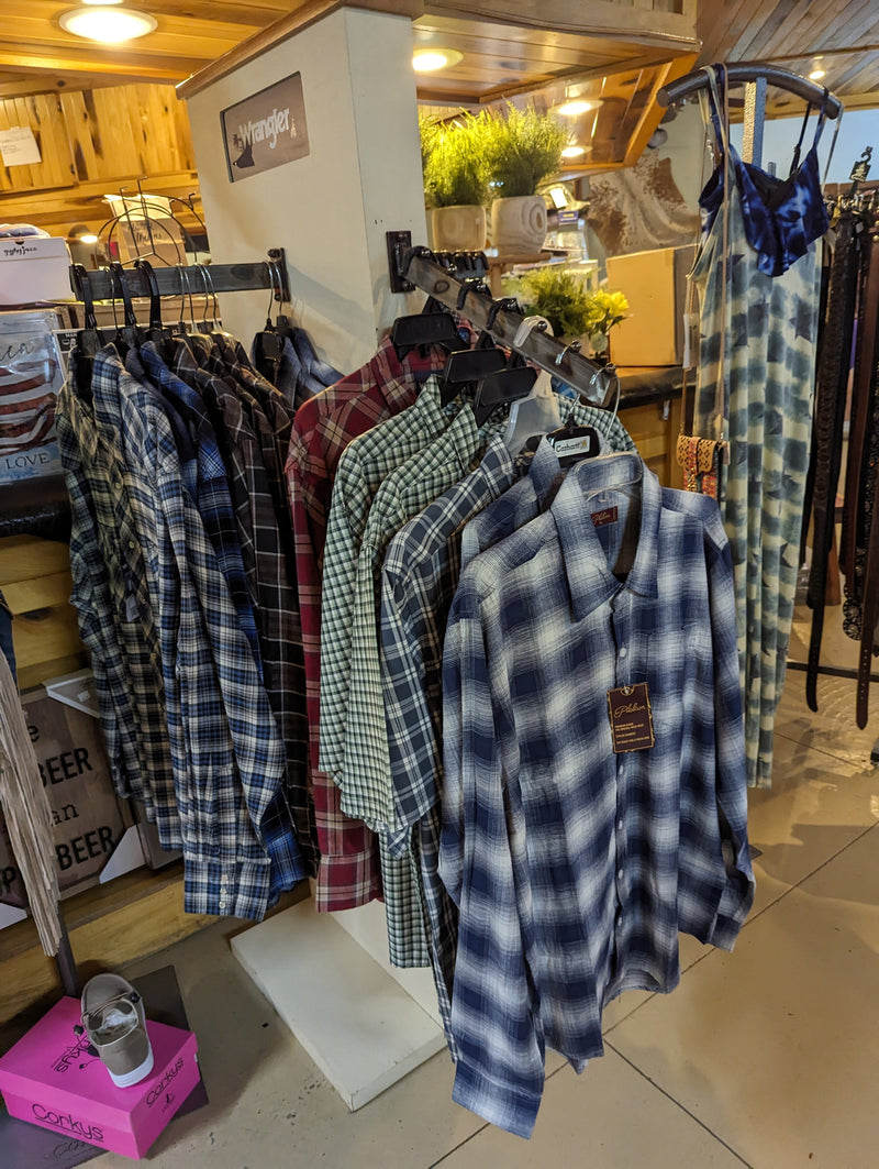 Mens western shirts hanging on a display in a store.