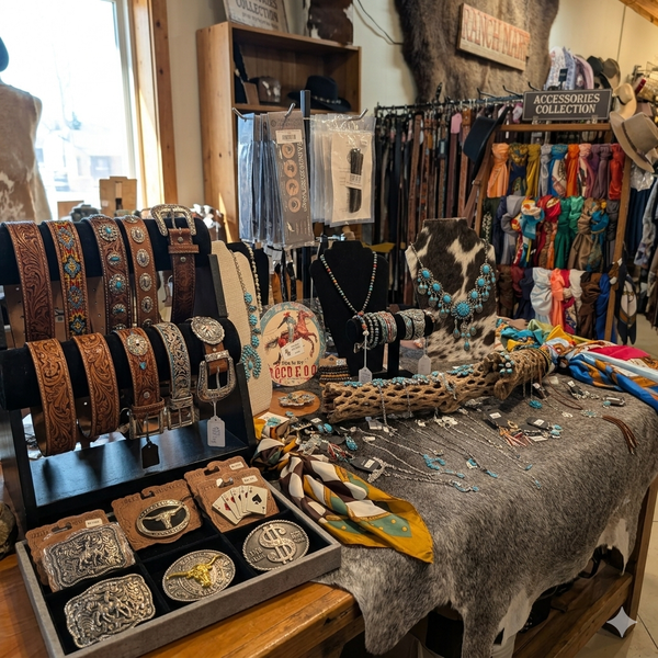 Western fashion accessories including wild rags, cowboy hats, leather belts, and rodeo buckles available at Ranch Mart