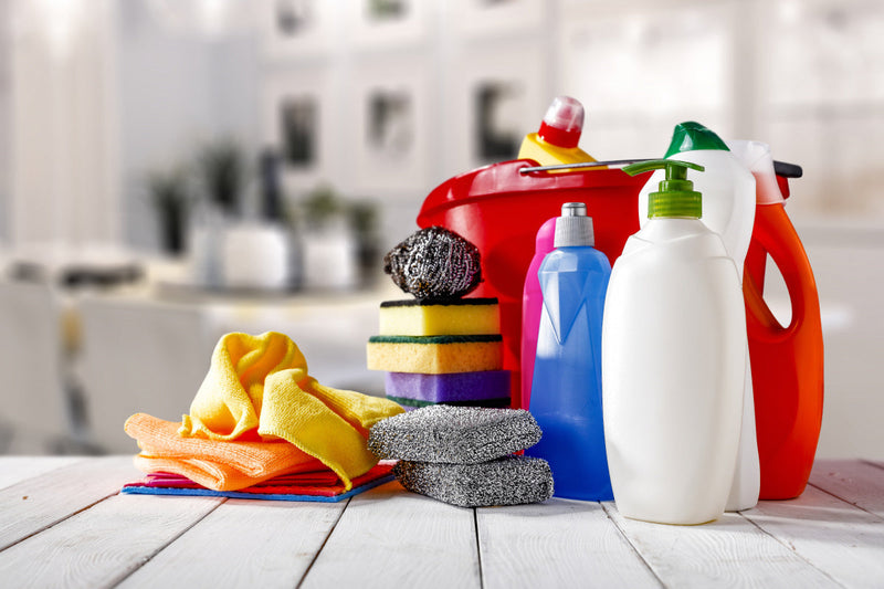 A varitey of cleaning products on a wood surface. 