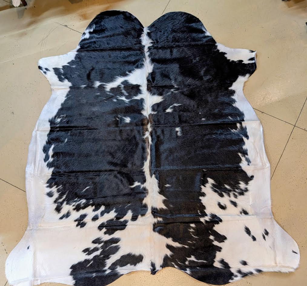Black and white cowhide rug on a tiled floor