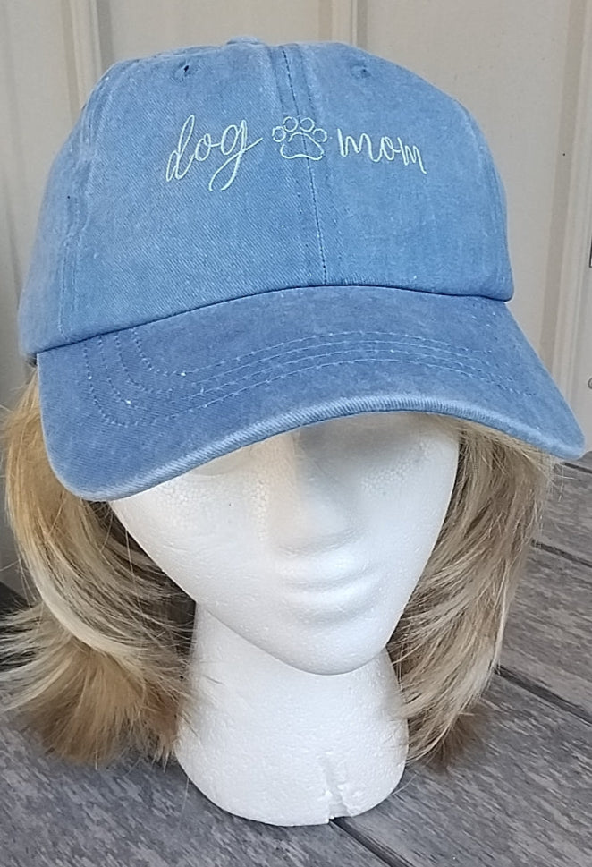 Blue cap on a mannequin head with text, placed on a wooden surface.
