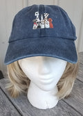 Blue denim cap with embroidered designs on a mannequin head against a neutral background