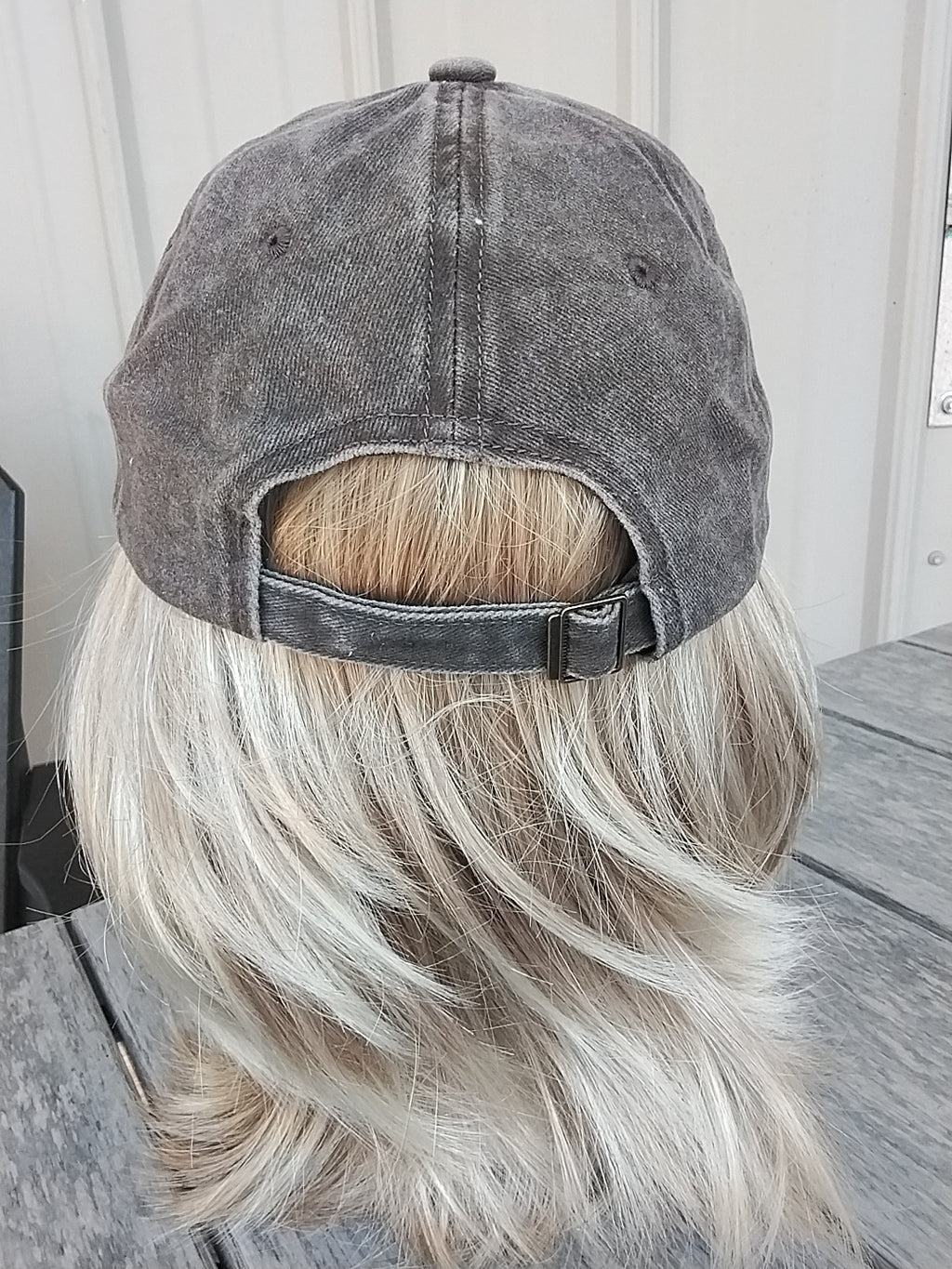 Gray cap on a mannequin head with blonde hair against a neutral background
