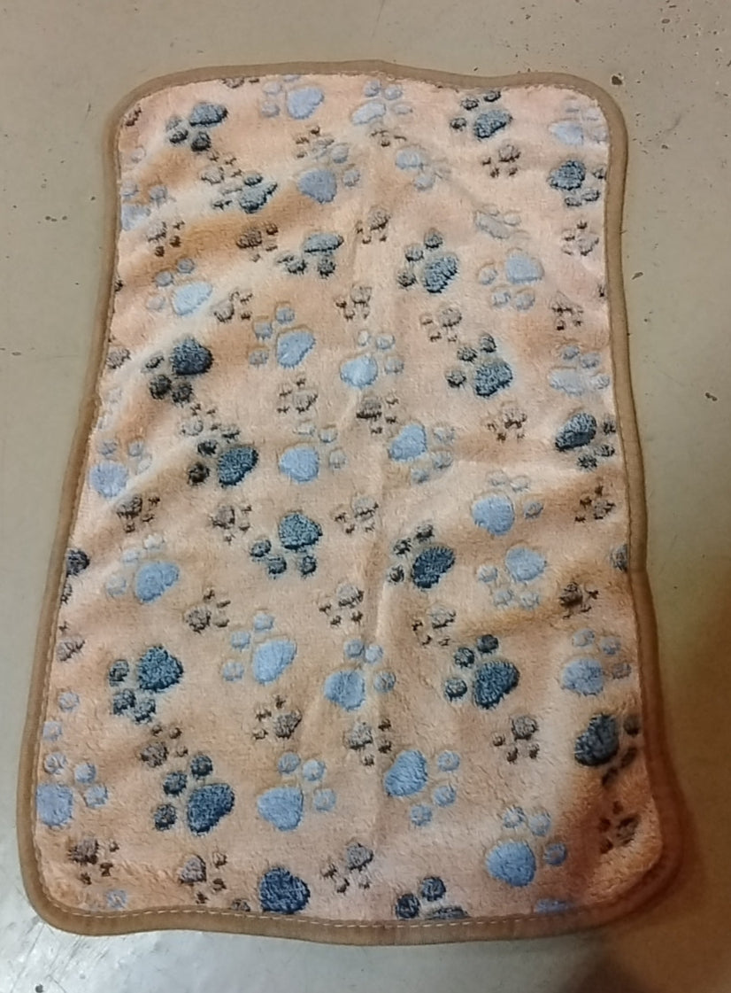 Beige mat with blue paw prints on a beige surface