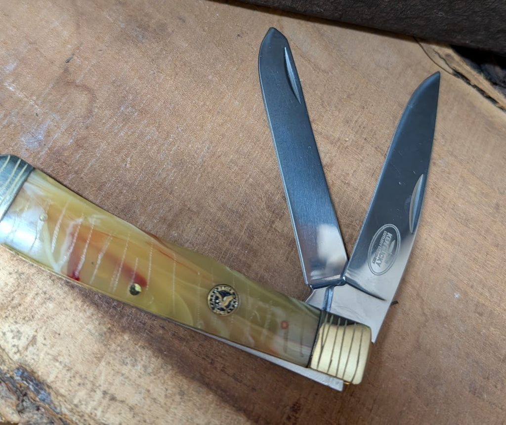 Trapper knife with a decorative handle on a wooden surface