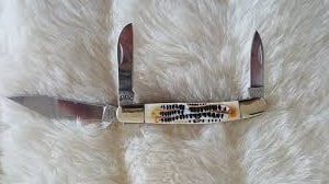 3 blade bone handle like knife on a white fluffy surface