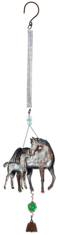 A rustic metal hanging ornament featuring a mother horse and foal design with a coiled spring, small blue bead, green bead, and brown bell at the bottom.