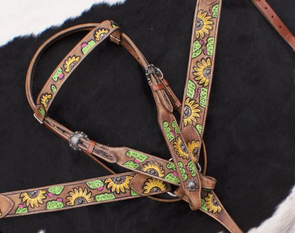 Brown leather bridle with sunflower pattern on a dark background