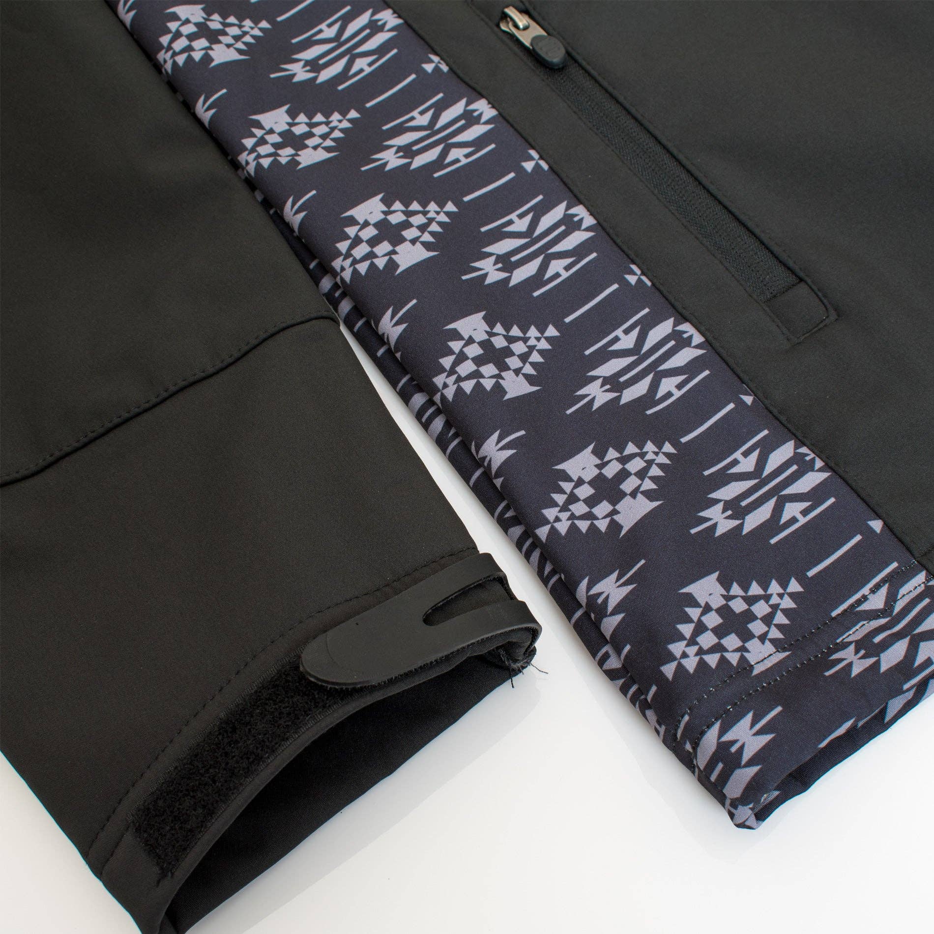 Black pants with a patterned waistband on a white background