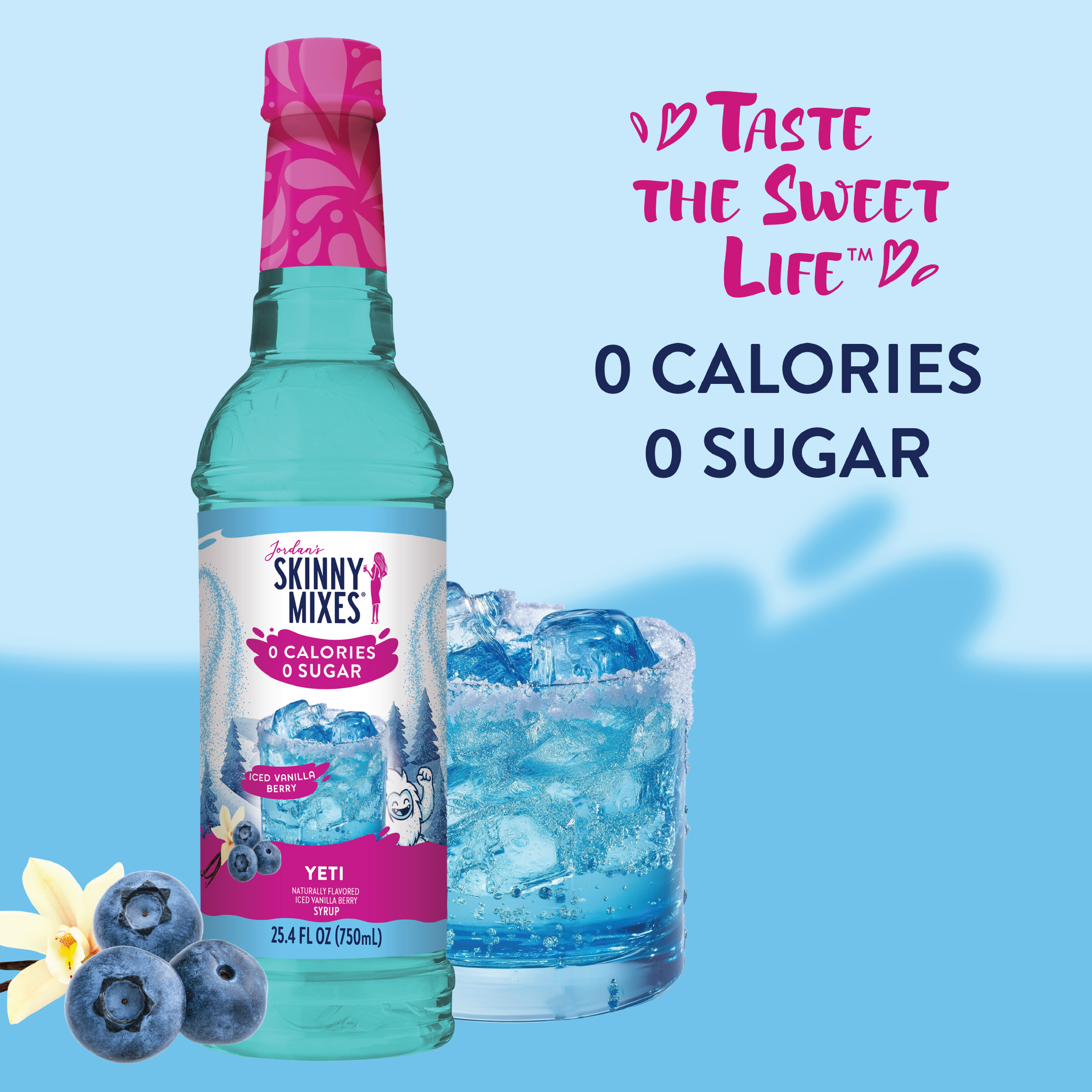 Bottle of Skinny Mixes with a glass of blue drink and ice, surrounded by blueberries and vanilla flowers on a light blue background.