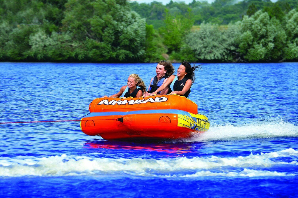 Three people on an Airhead tube in a lake 