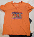 Orange Graphic Tee with LLL on a black and white cowhide rug. 