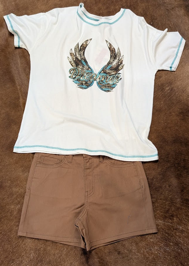 White t-shirt with graphic design and brown shorts on a brown textured surface