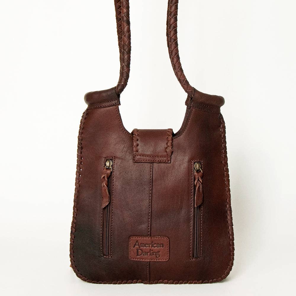 Brown leather handbag with 'American Darling' label on a white background