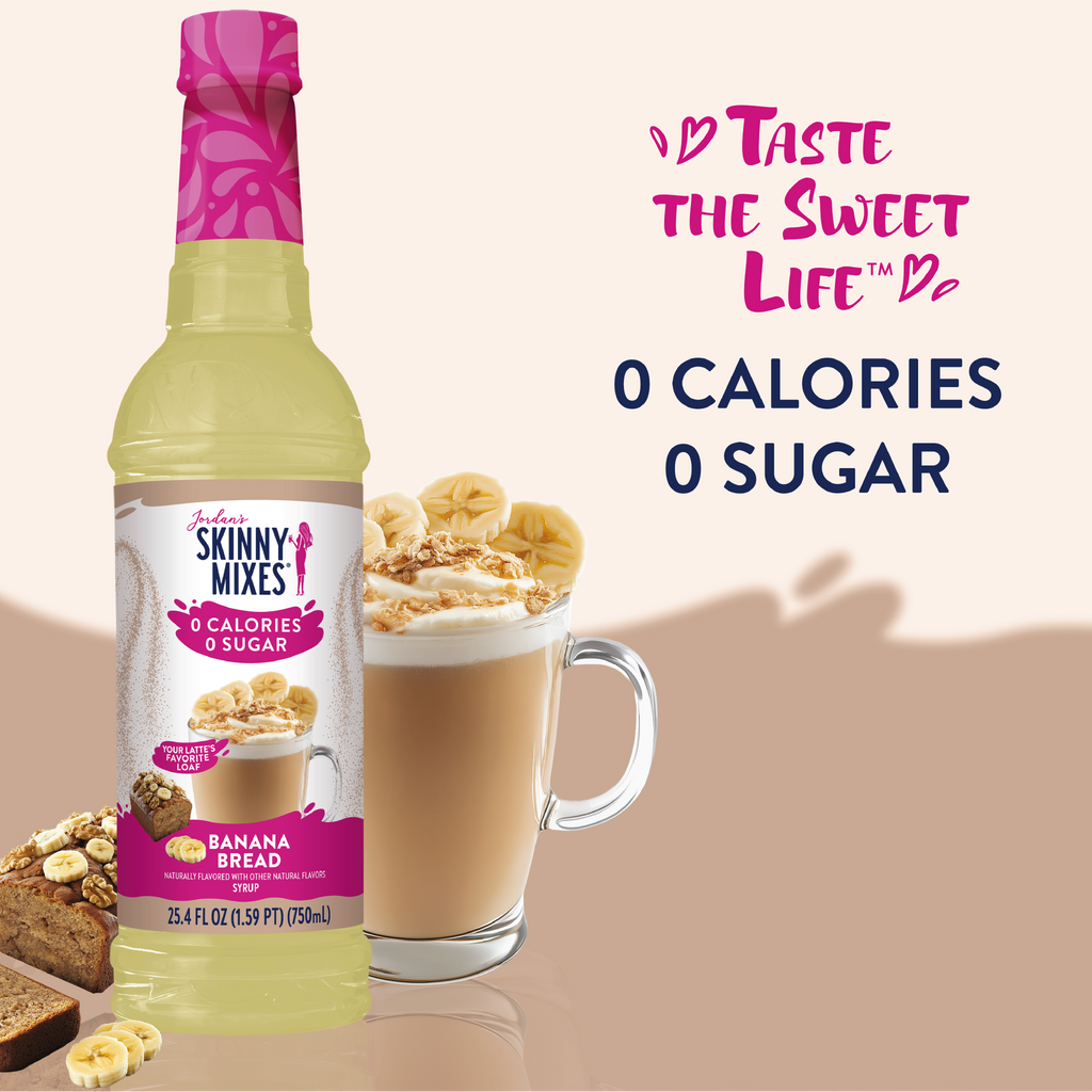 Skinny Mixes banana bread syrup bottle with a glass of coffee and banana slices on a beige background.