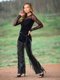 Closeup of black vegan leather pants with dramatic fringe detailing, perfect for western glam and performance wear