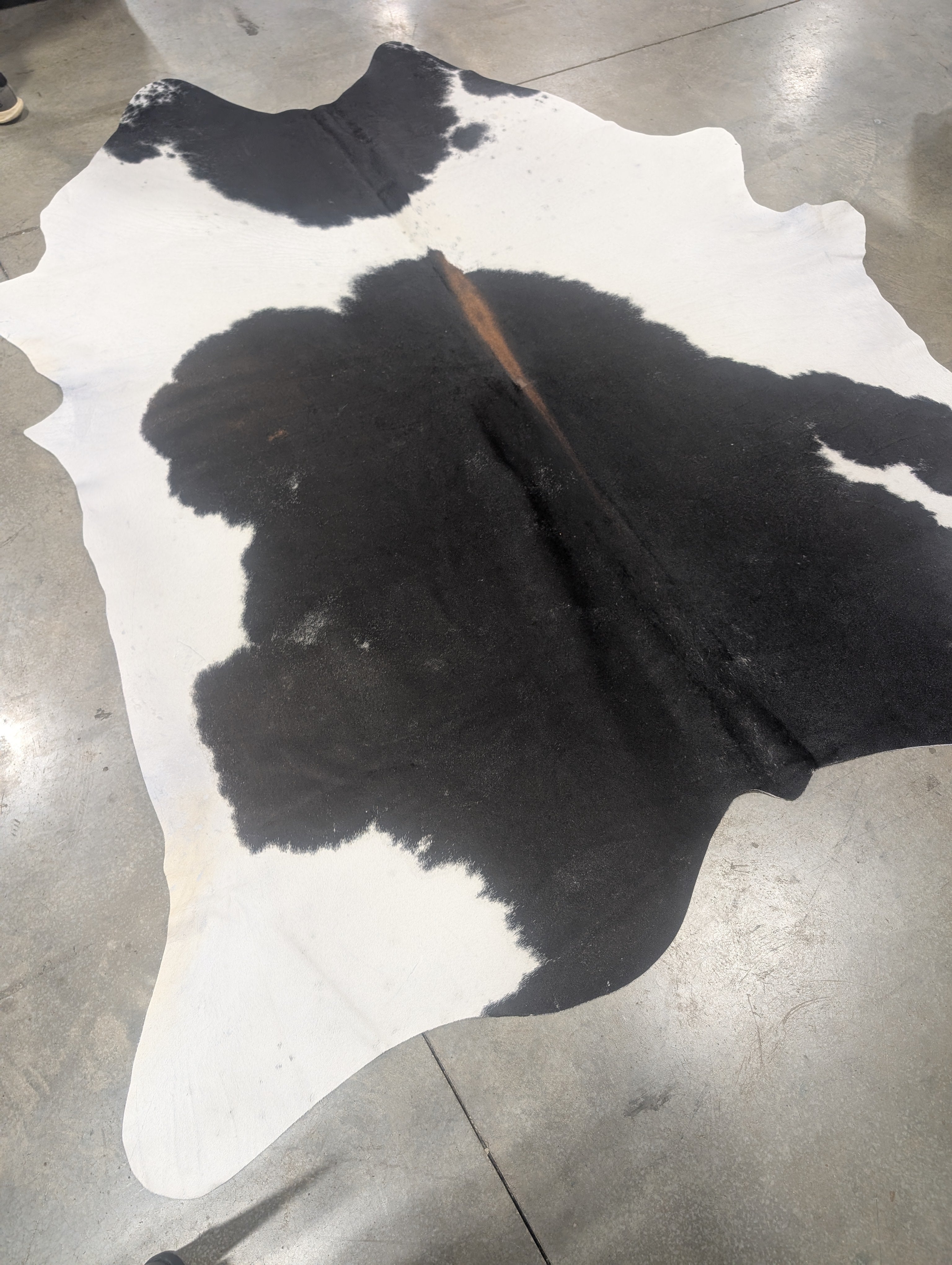 cowhide rug on a grey floor
