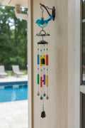 Colorful wind chime attached to a hook in an outdoor setting