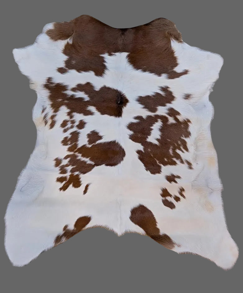 Red and white speckled calf hide on a gray floor