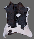 Brown, black, and white cowhide rug on a gray floor.