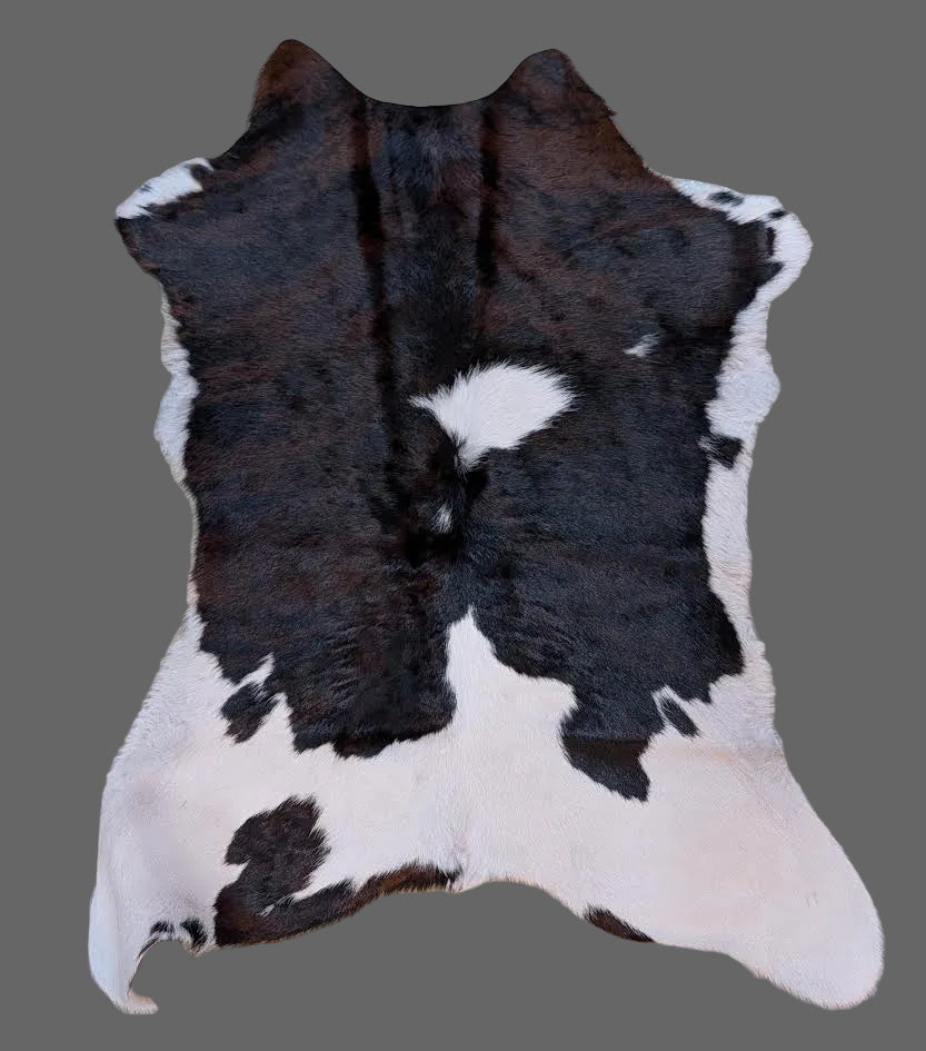 Brown, black, and white cowhide rug on a gray floor.
