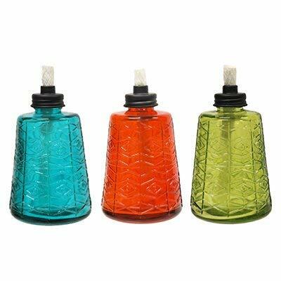 Colorful 13-OZ Tiki Glass Table Torch in red, blue, and green on a wooden outdoor table, glowing warmly at night.
