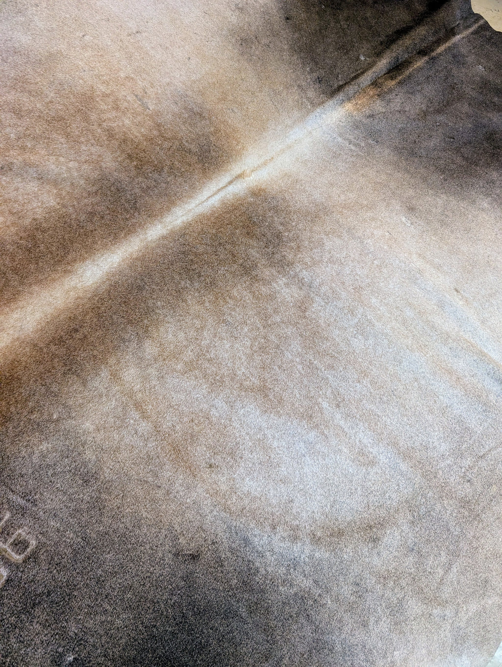 Authentic smokey brown cowhide with natural branding 
