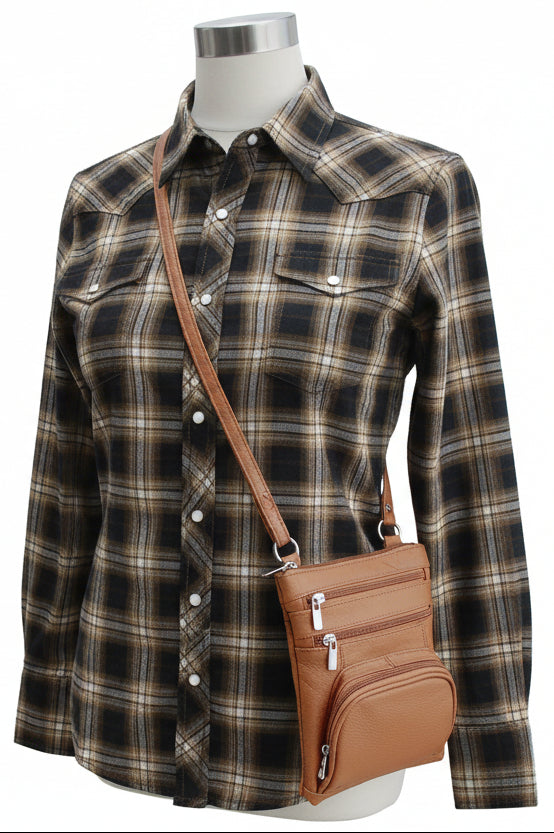 Tan leather crossbody bag on a mannequin wearing a western button up shirt with a white background