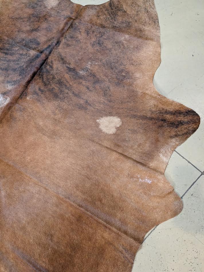 Close-up of a brown cowhide rug on a tiled floor