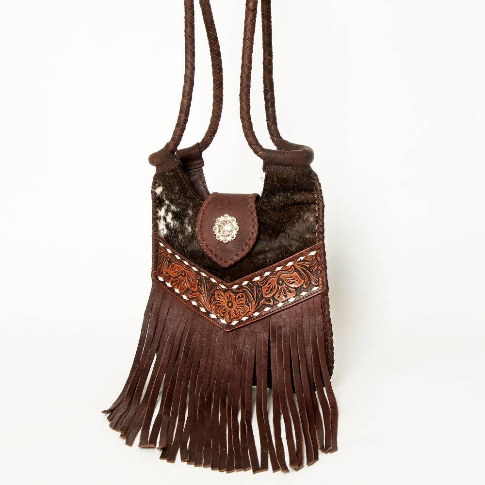 Brown leather handbag with fringe and decorative elements on a white background